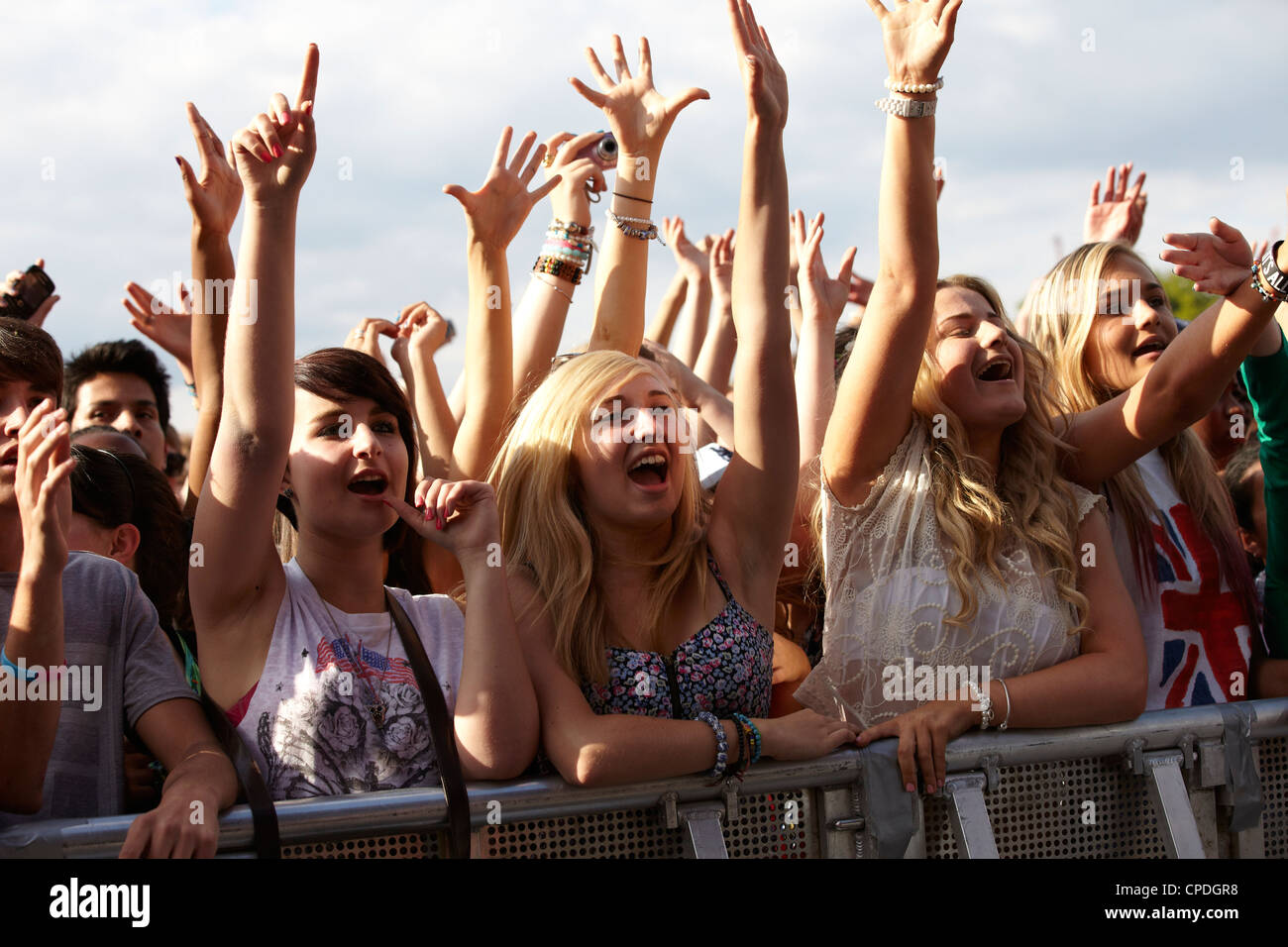 Crowd in the front row at front of the stage at a music festival in the ...