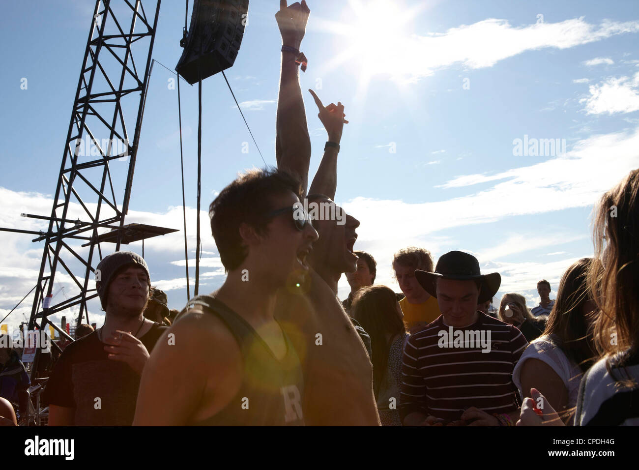 Young people dancing and cheering in the sunshine at a music festival party Stock Photo
