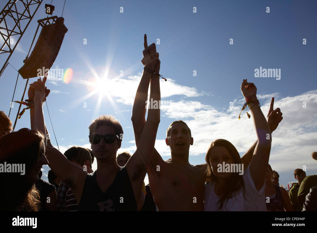 Young people dancing and cheering in the sunshine at a music festival party Stock Photo