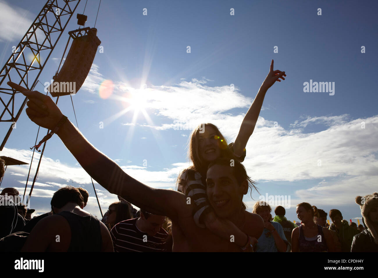 Young people dancing and cheering in the sunshine at a music festival party Stock Photo