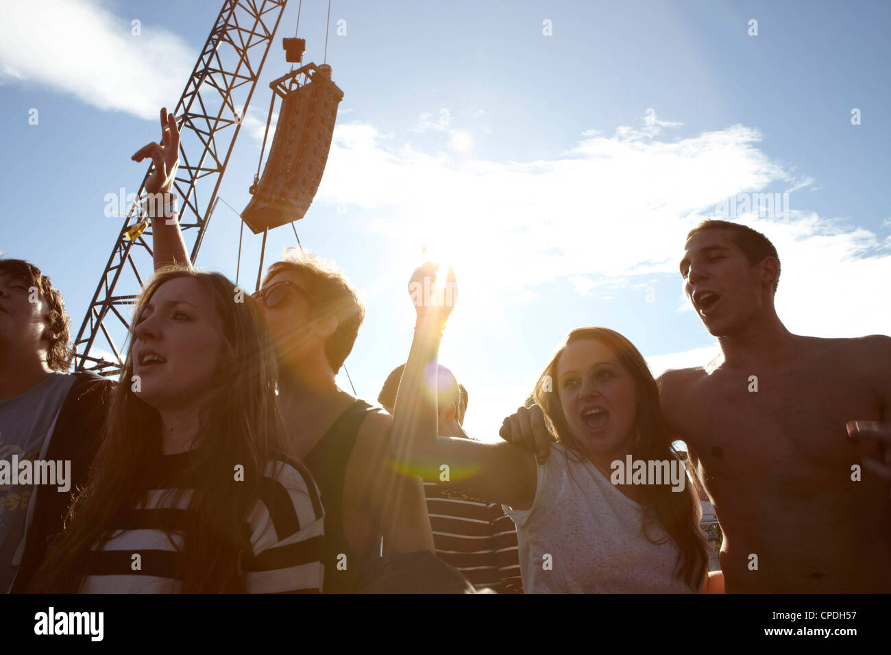 Young people dancing and cheering in the sunshine at a music festival party Stock Photo