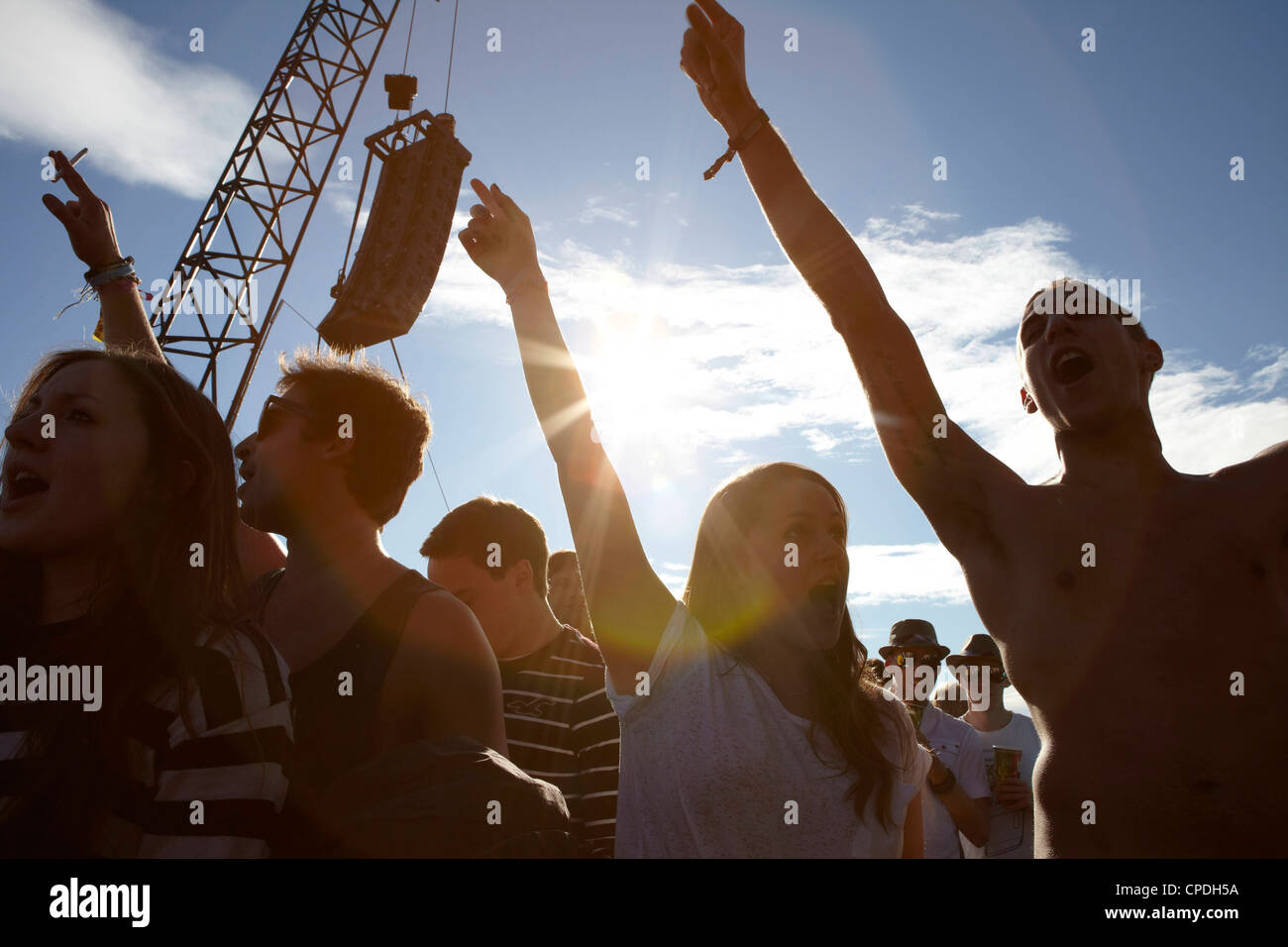Young people dancing and cheering in the sunshine at a music festival party Stock Photo