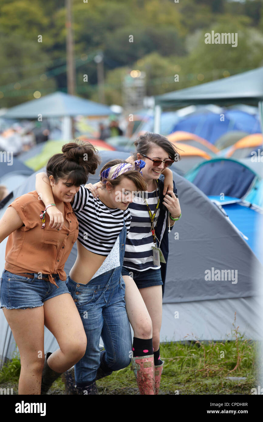 Girls Walking Through Festival Campsite Arm In Arm Laughing And Giggling Stock Photo Alamy