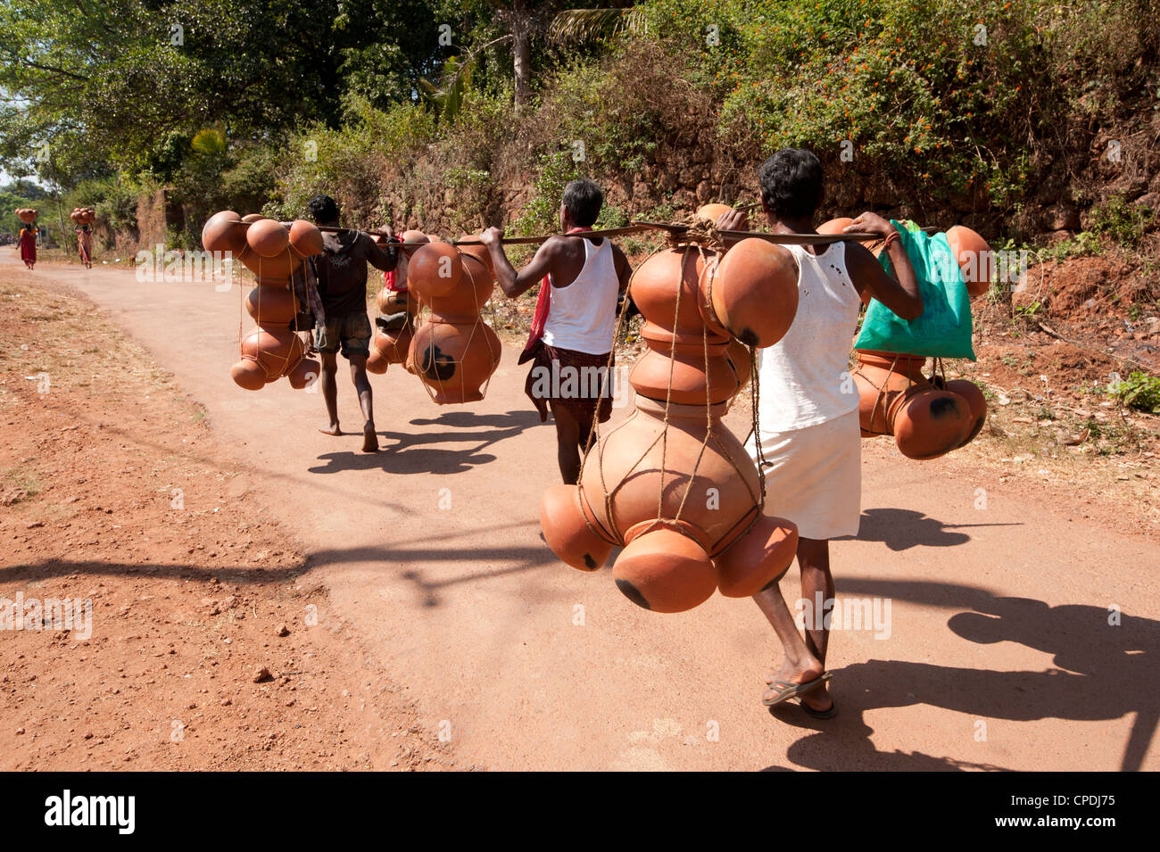 Bonda tribesmen walking to market carrying pots intended for village alcohol production, rural Orissa, India, Asia Stock Photo