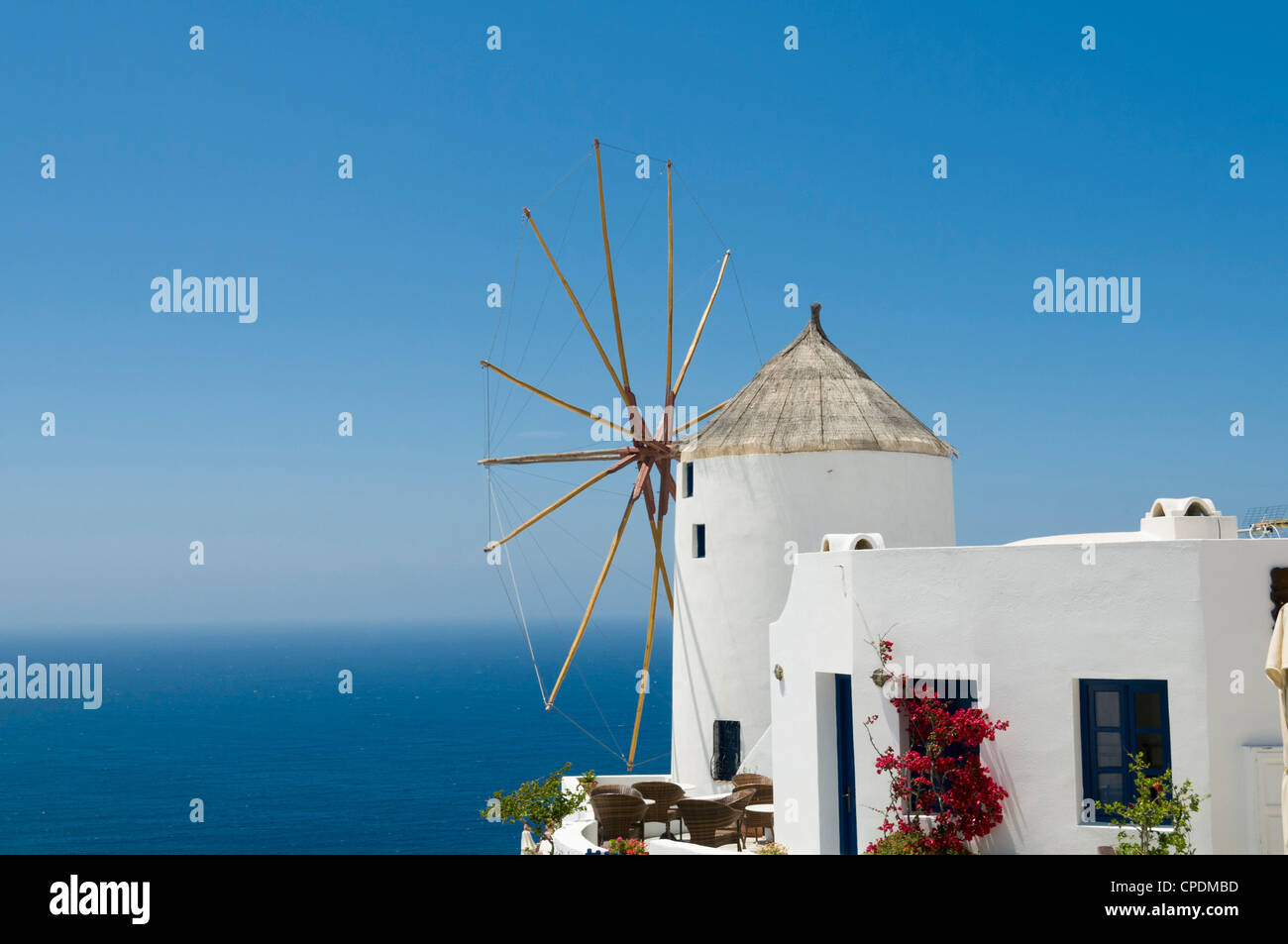 White windmill in the village of Oia, Santorini, Greece overlooking the sea Stock Photo