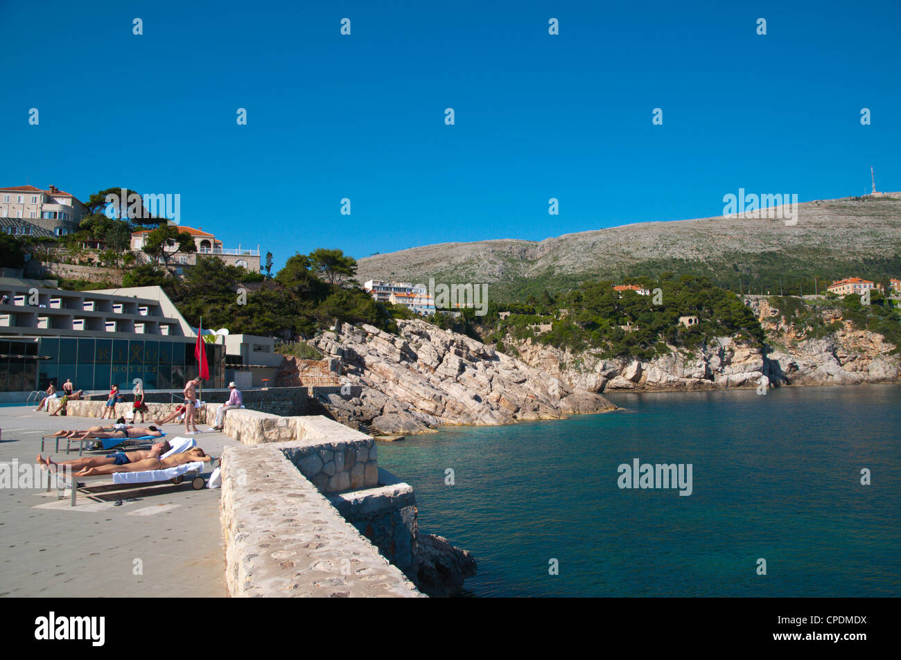 People sunbathing on the seafront terrace of Rixos Libertas chain hotel Dubrovnik city Dalmatia Croatia Europe Stock Photo