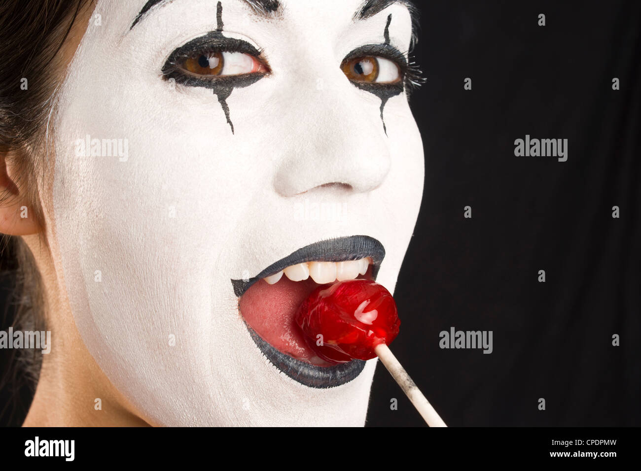 A Mime enjoys a lollipop in an up close portrait. Stock Photo
