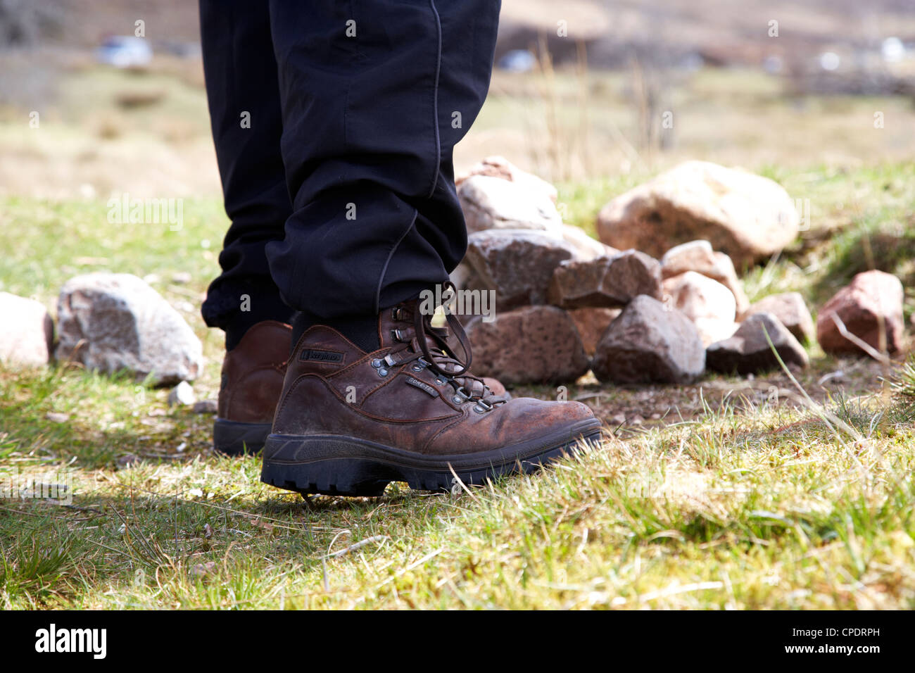 hiker hillwalker standing near camp site fire spot in the highlands of Scotland UK Stock Photo