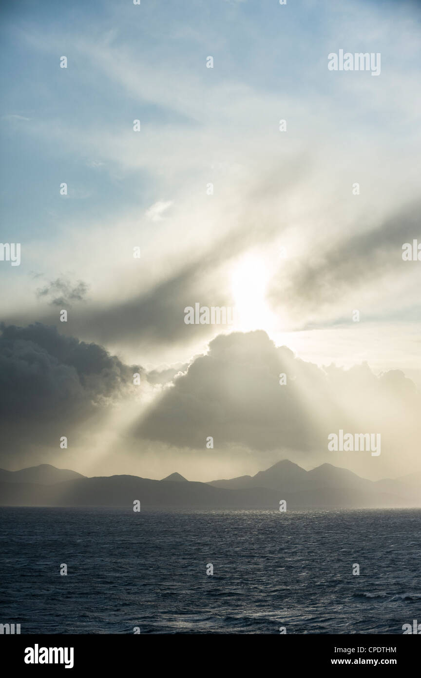 Dramatic storm clouds and shafts of sun light over The Cuillin on the Isle of Skye from Applecross, Highlands, Scotland, UK Stock Photo