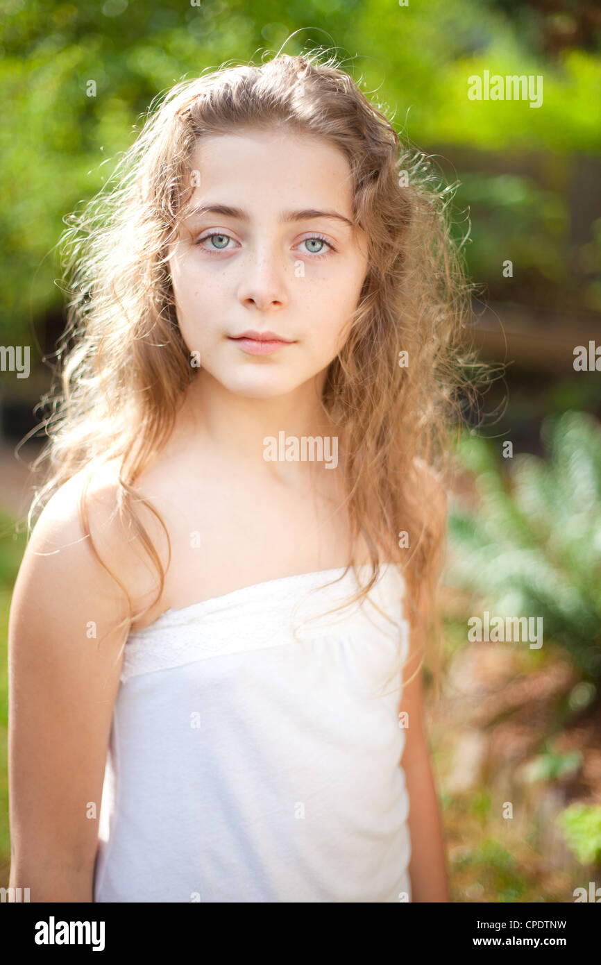 A Young Teen Girl With Long Curly Blond Hair Is Outside L