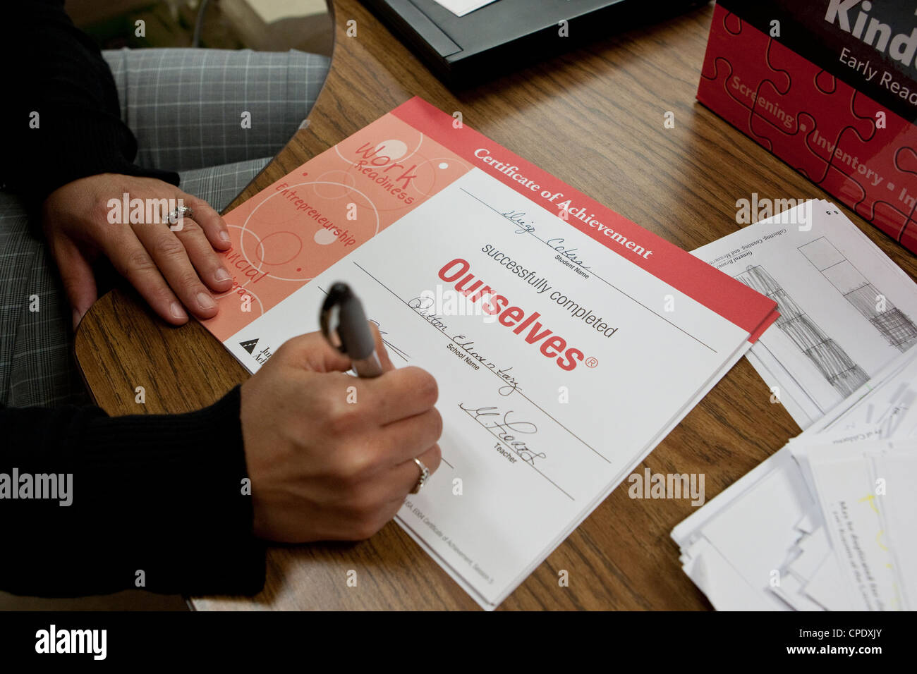 Kindergarten Teacher Fills Out A Certificate Of Achievement For Students Of Texas Public Elementary School Stock Photo Alamy