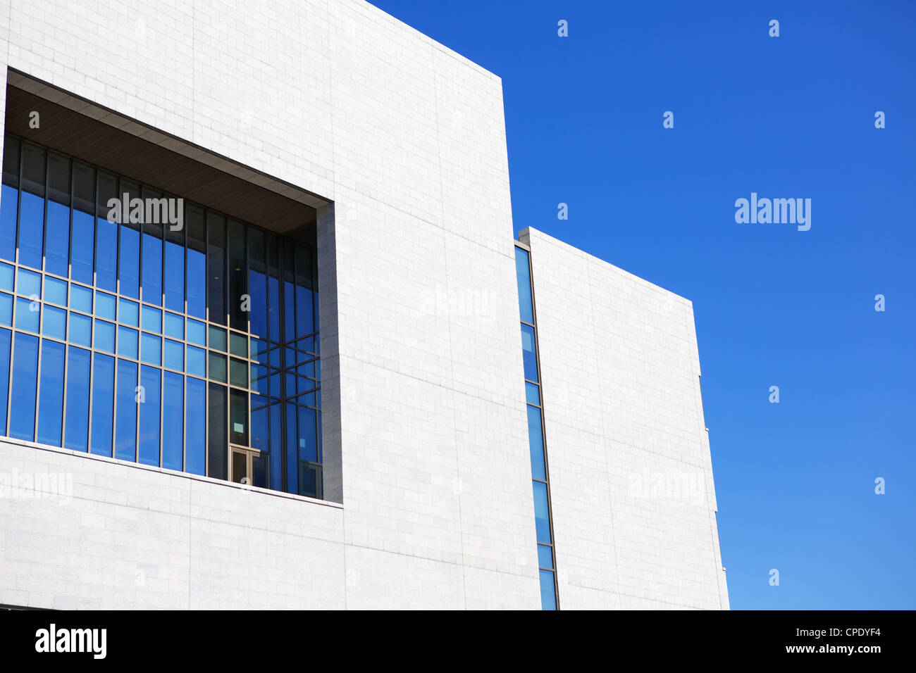 Bright new building with blue green windows against a clear blue sky Stock Photo