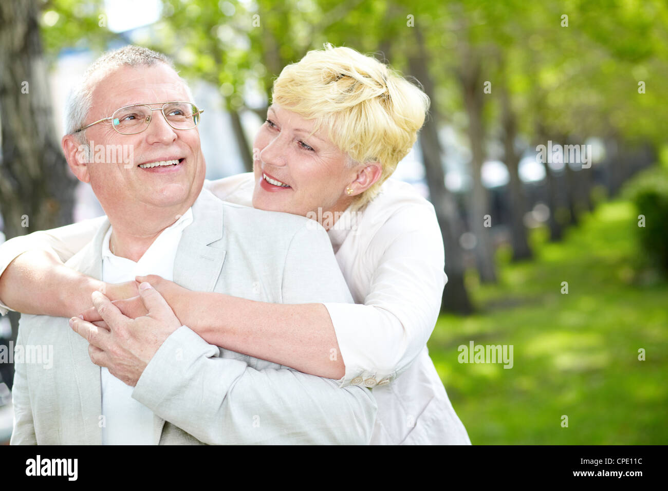 Portrait of happy mature woman hugging her husband outside Stock Photo