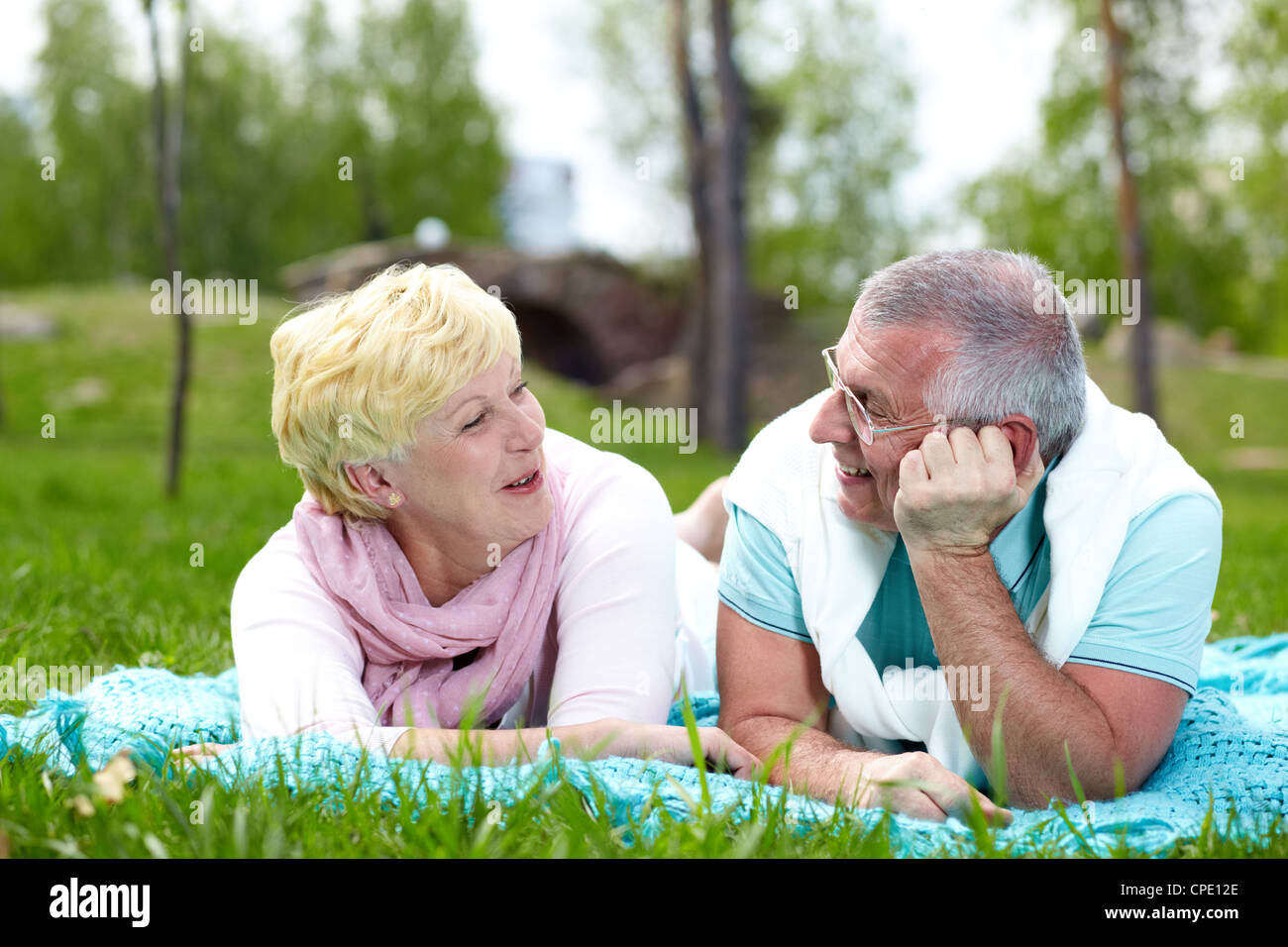 Happy mature couple lying on grass and talking in the countryside Stock ...