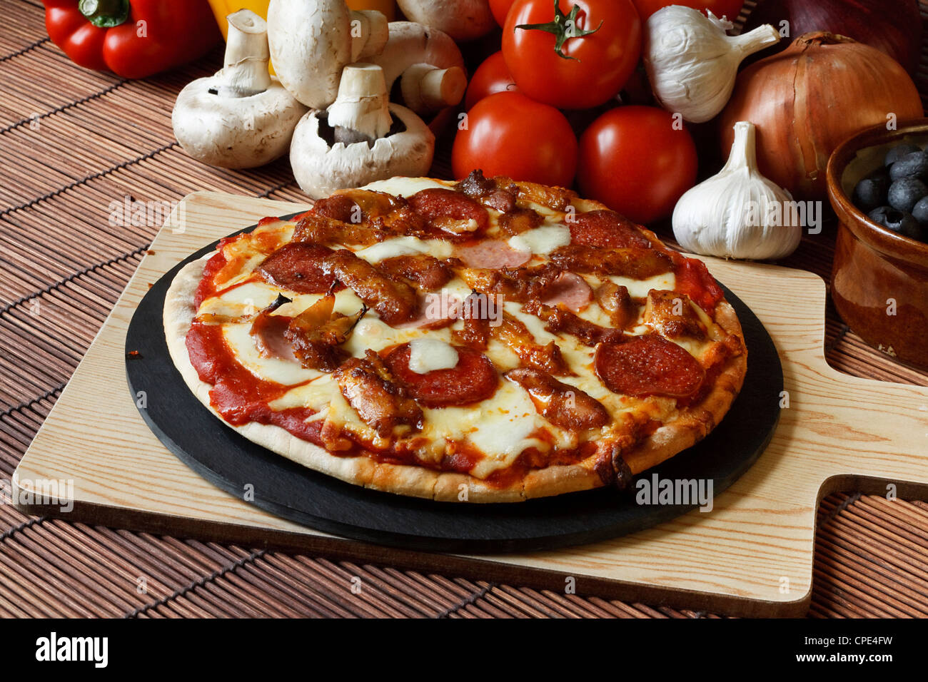 Barbecue or BBQ meat feast pizza with a topping of pepperoni, sausage, salami and chicken wings Stock Photo