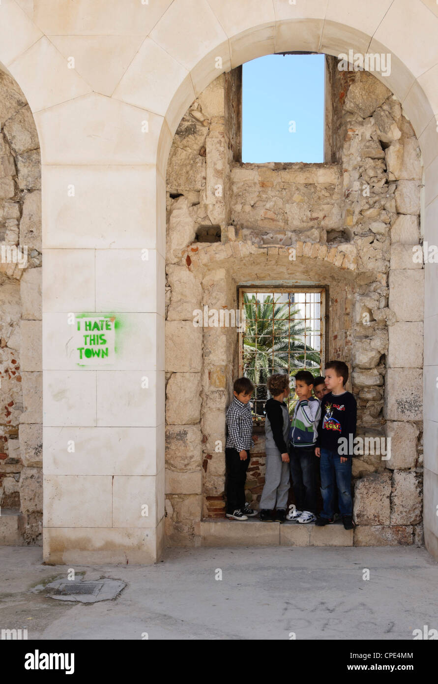 Split - Diocletian's Palace, olf walled heart of city. Children visiting the city, graffiti says 'I hate this city'. Stock Photo