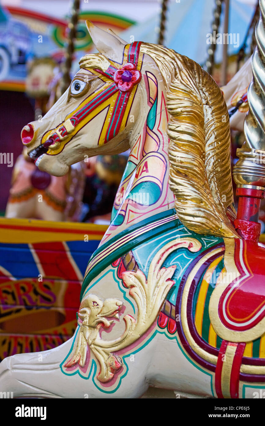Children's horse ride on a traditional steam fairground merry-go-round UK Stock Photo