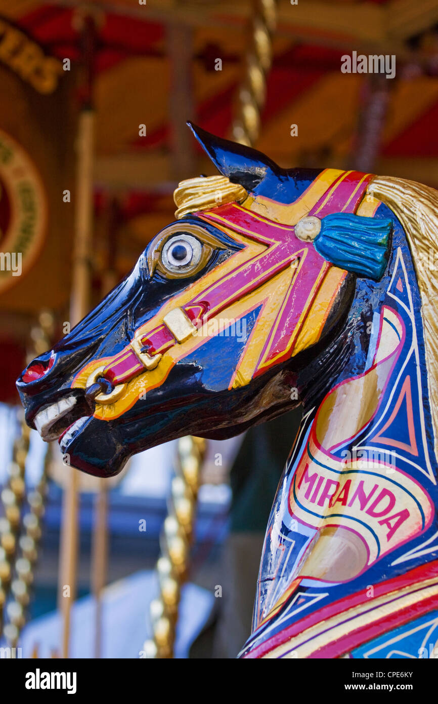 Children's horse ride on a traditional steam fairground merry-go-round UK Stock Photo