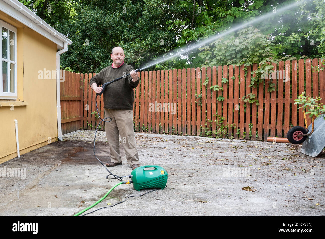 Man with garden hose pipe Stock Photo