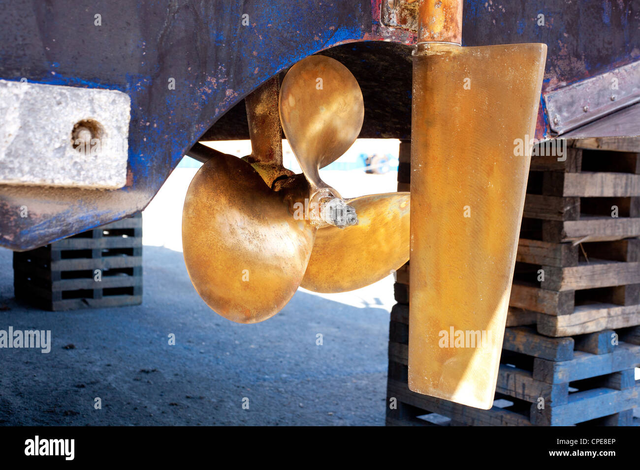 brass boat propeller and steering in beached ship Stock Photo