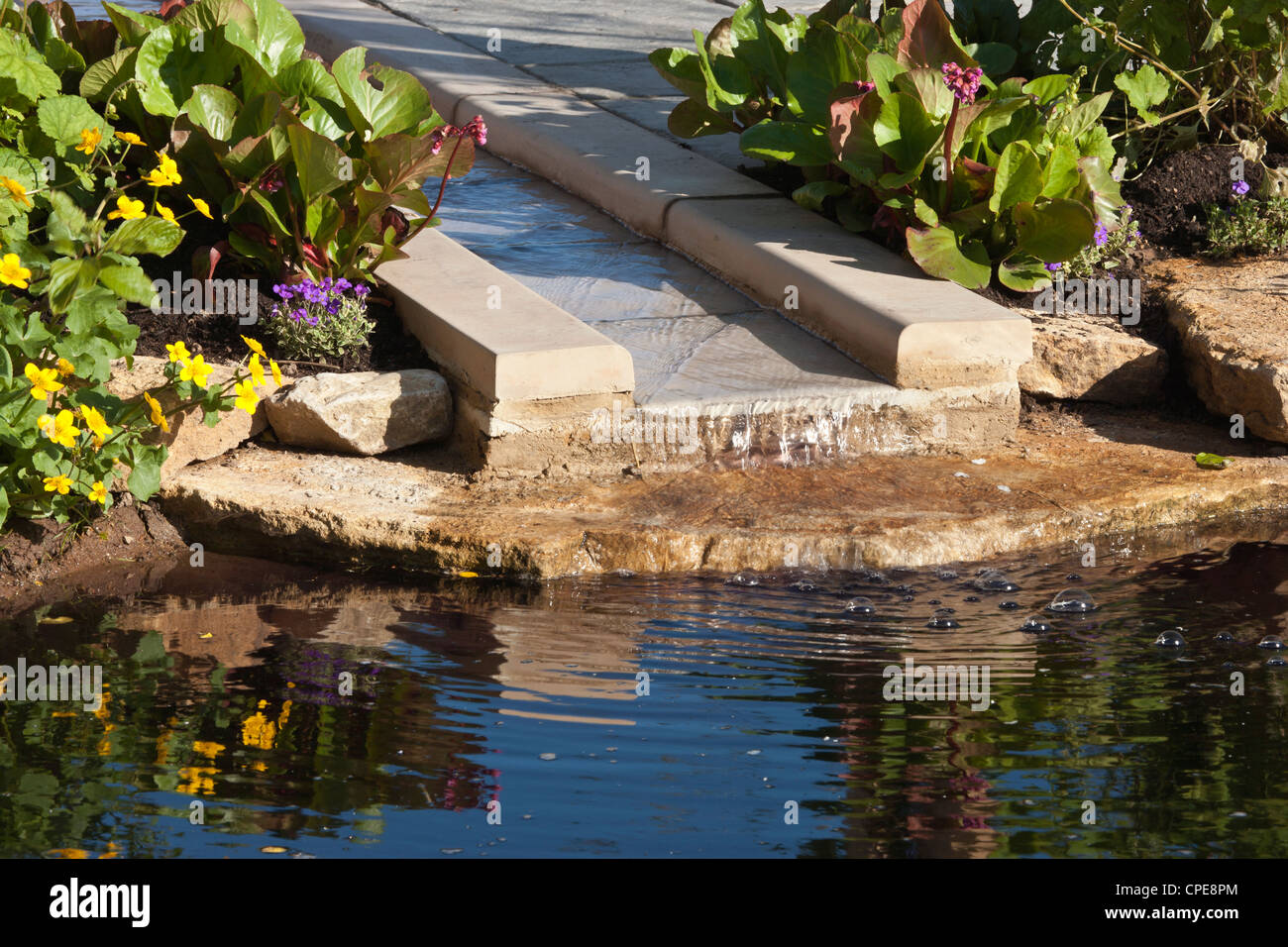 a garden with garden rill water feature made from stone water marginal