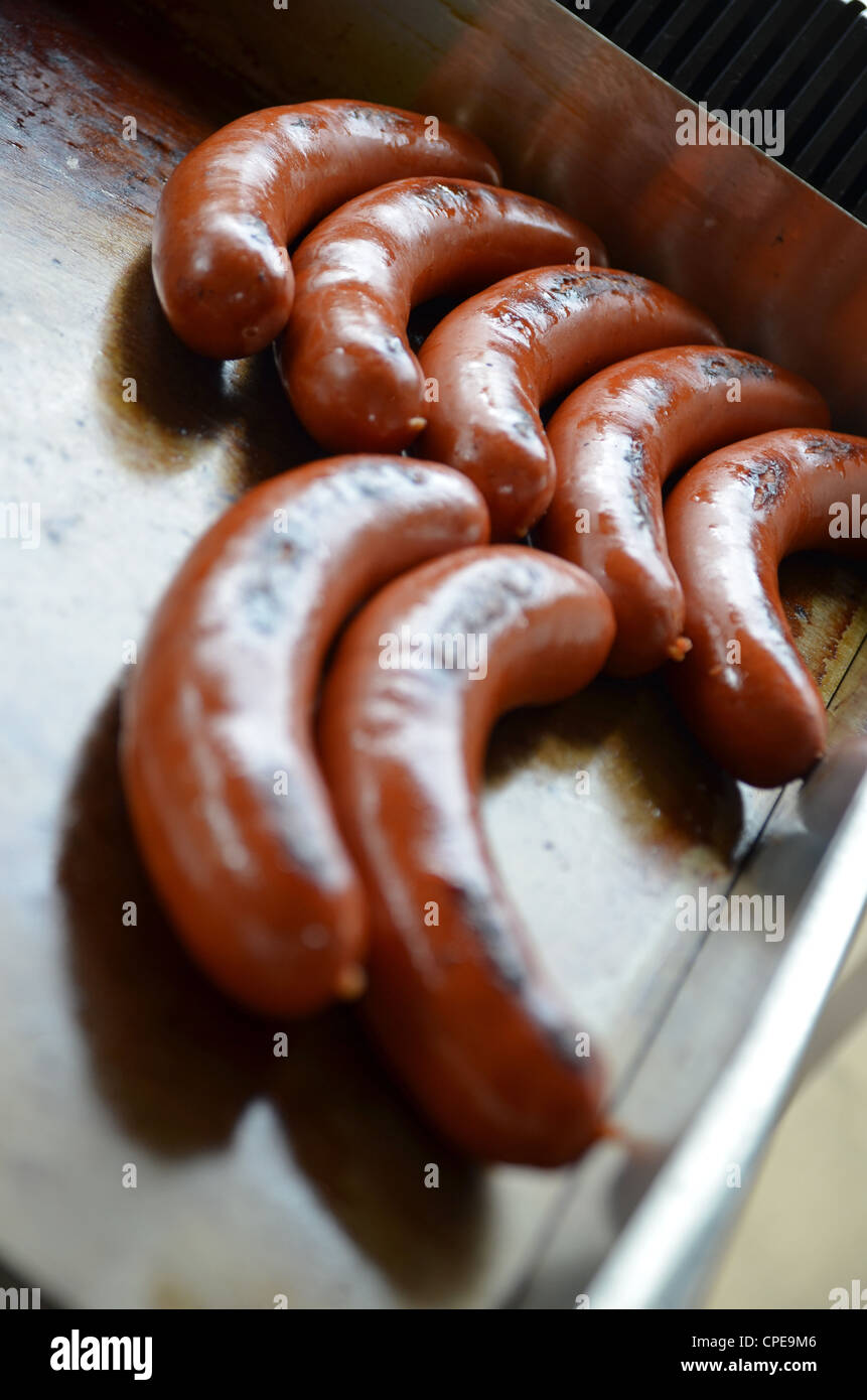Hot dog sausages cooking on a griddle on a food stall Stock Photo Alamy