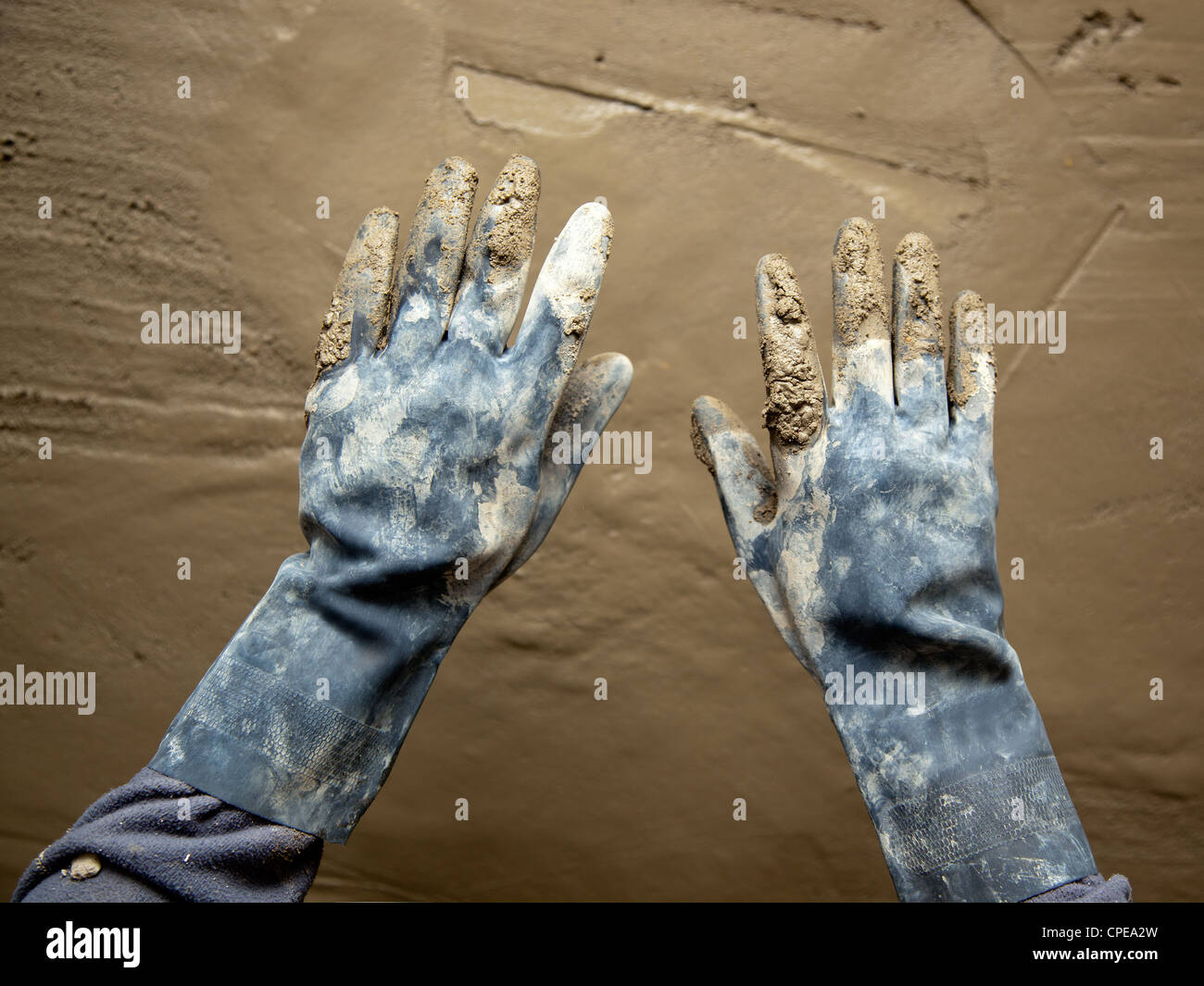 dirty grunge gloves hands on cement mortar fresh wall Stock Photo