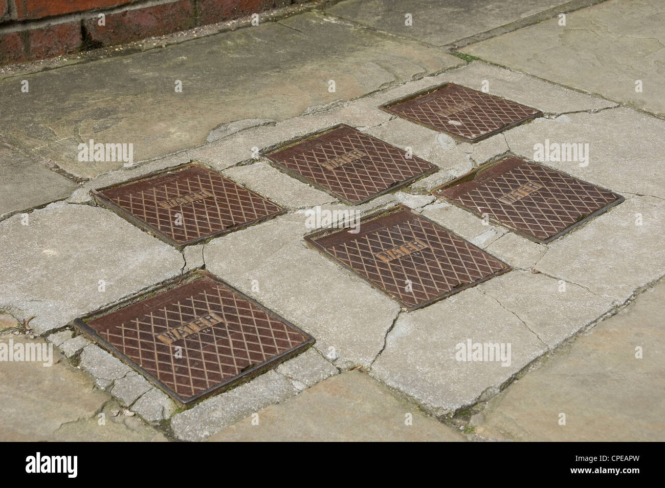 Close up of water meters meter cover covers set in the pavement England UK United Kingdom GB Great Britain Stock Photo