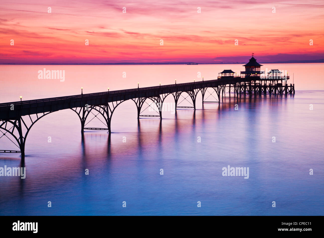 The sun sets over the Bristol Channel behind the Pier at Clevedon, Somerset, England, UK Stock Photo