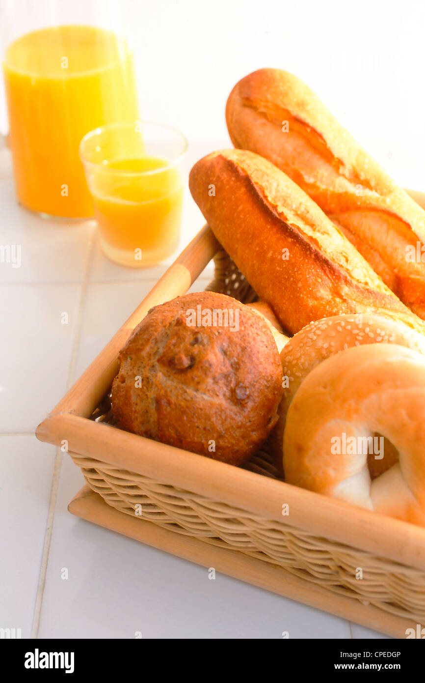 Assorted Bread Rolls In Wooden Tray And Orange Juice Stock Photo