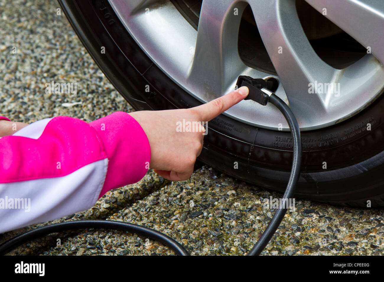 Adding air in car tire -correct level to save gas Stock Photo