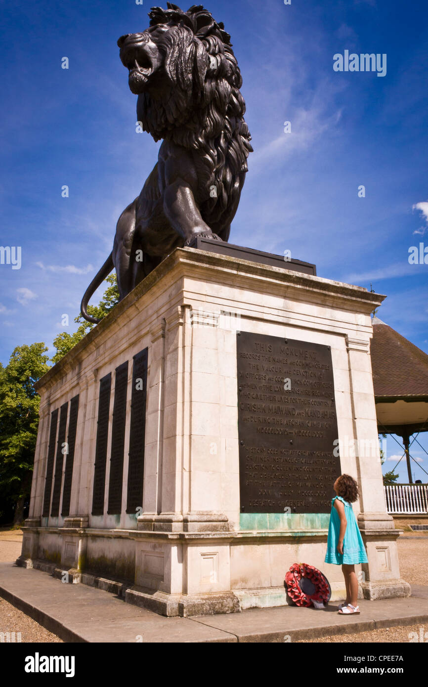 A young child stands before the Maiwand Lion statue, Reading, Berkshire, England, UK Stock Photo