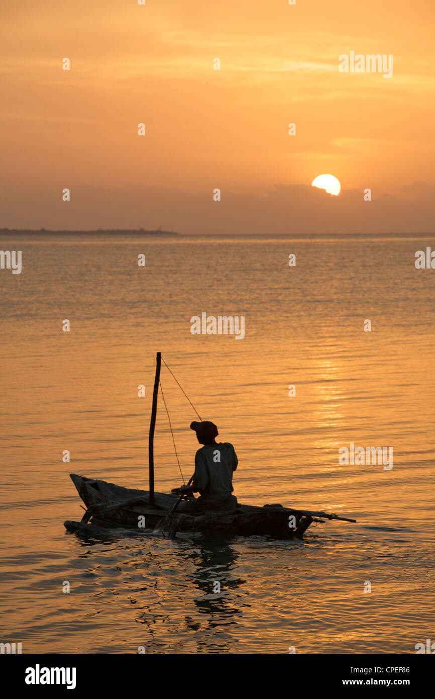 A man setting off in his one-man sailing boat (mitumbwi) in the Quirimbas archipelago in northern Mozambique. Stock Photo