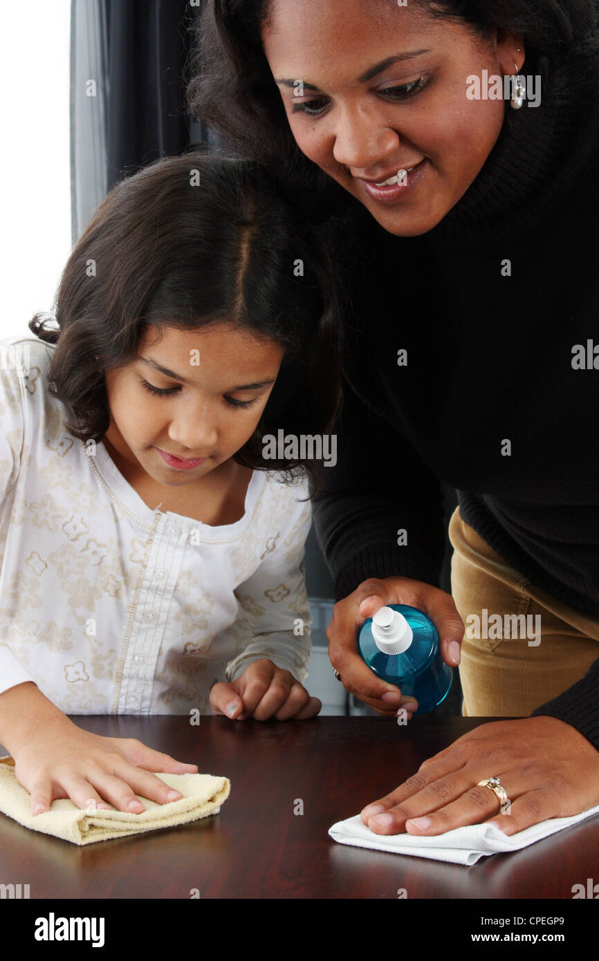 Minority woman and her daughter cleaning the table Stock Photo
