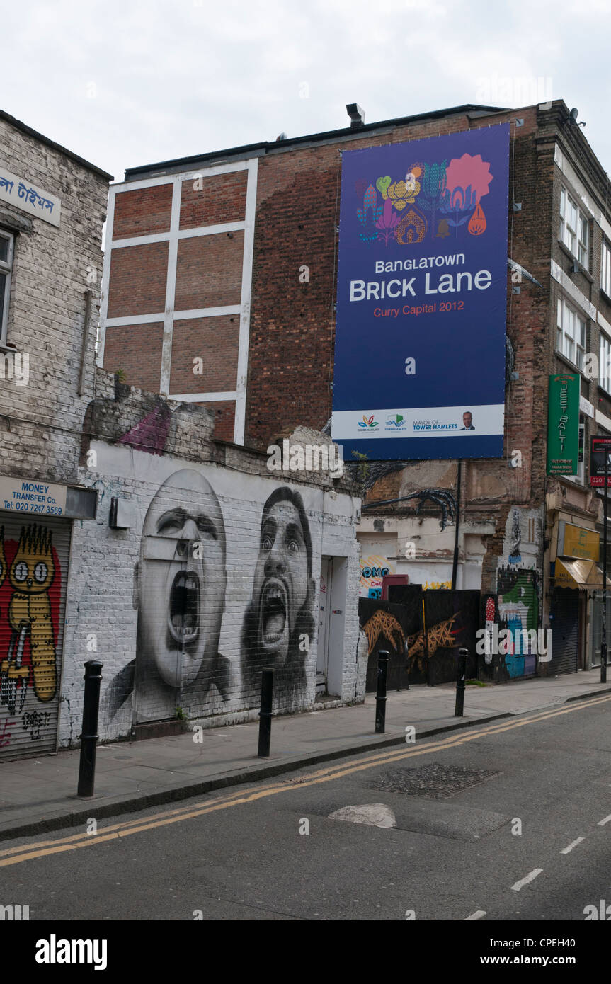 Advertisement for 'Banglatown Curry Capital 2012' in Hanbury St, off Brick Lane, London covering street art by the artist Roa. Stock Photo