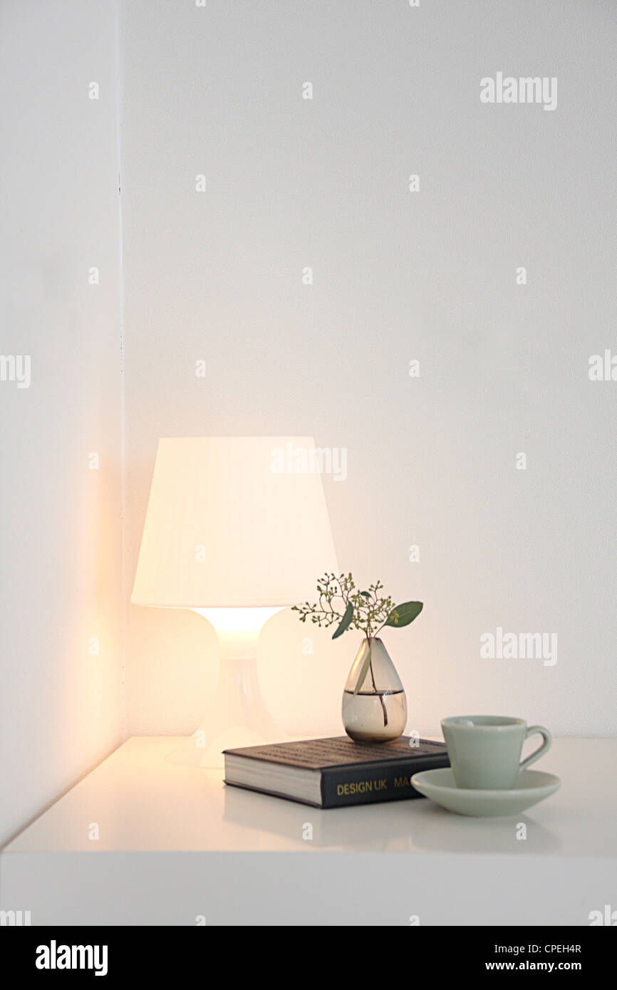 Lamp, Book, Vase And Teacup On Table Stock Photo