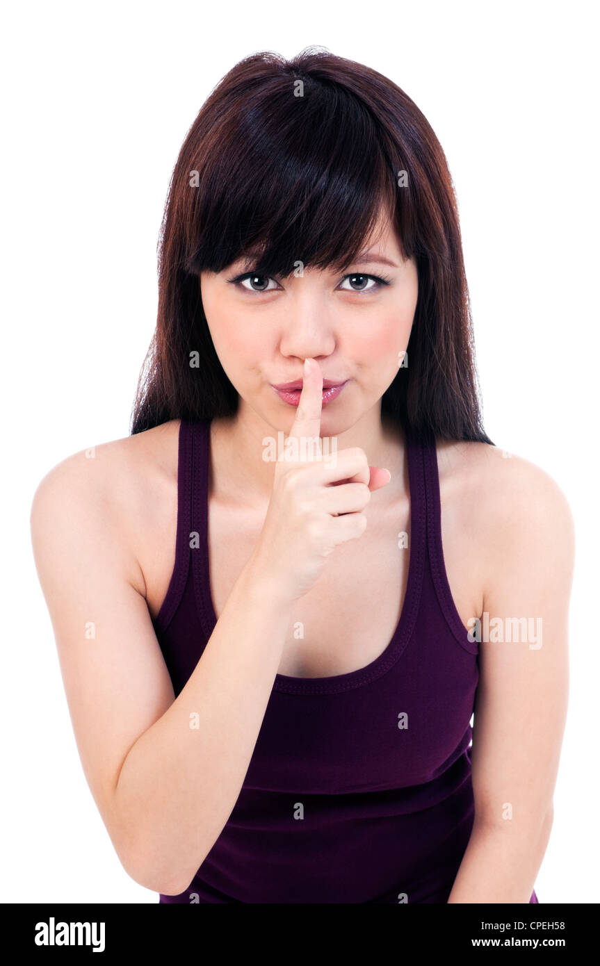 Cute young woman with finger on her lips Stock Photo - Alamy