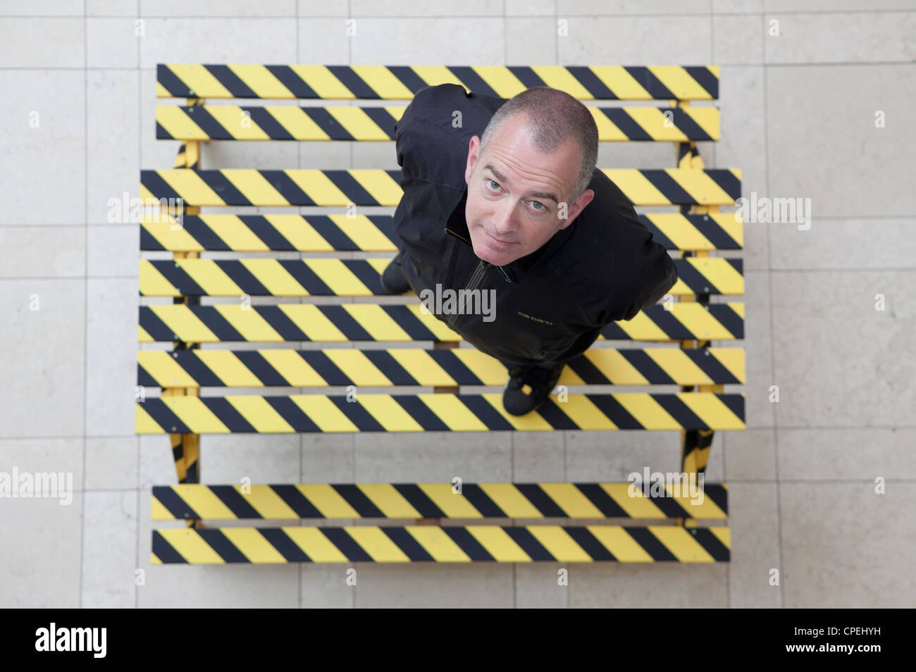 Author and DJ Dave Haslam on a Hacienda designed bench being auctioned for charity Stock Photo