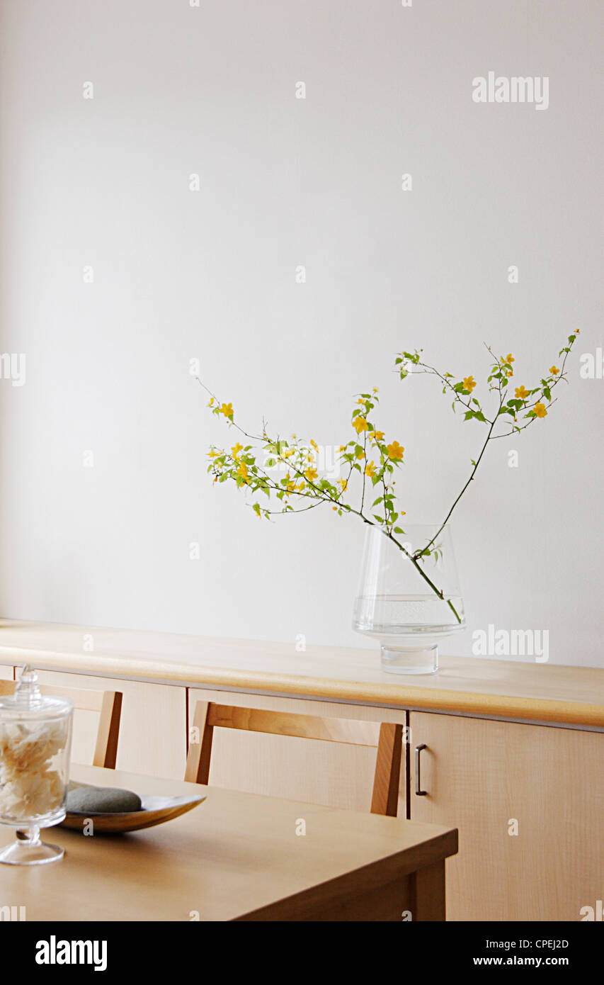 Dining Table With Potted Plant In Behind On Cupboard Stock Photo