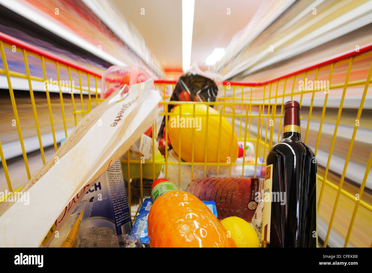 shopping cart in motion between blurred shelves in a supermarket Stock Photo