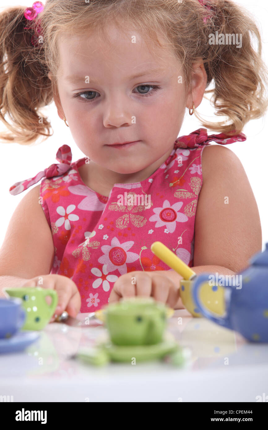 Young girl playing with her tea set Stock Photo - Alamy