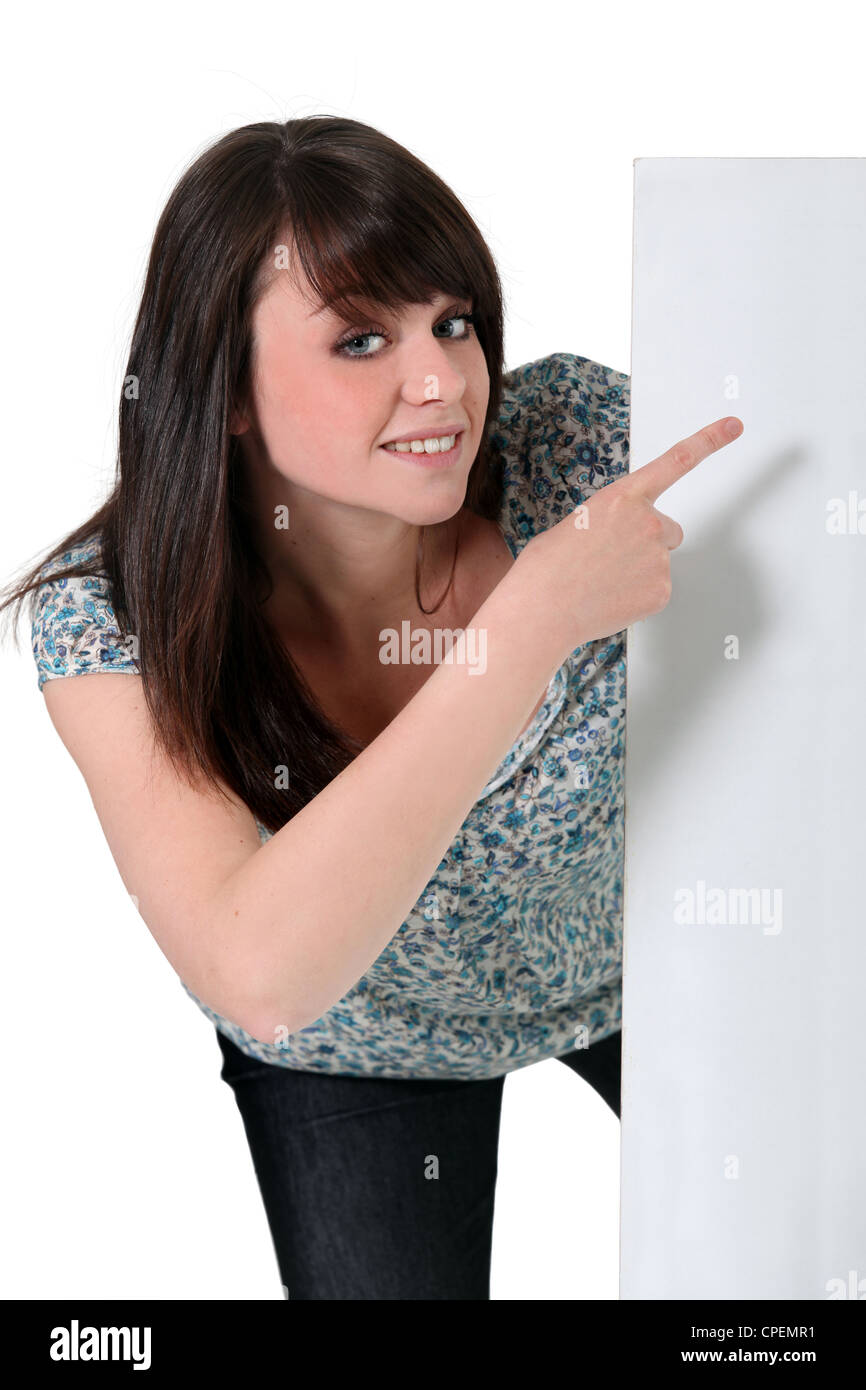 Teenage girl pointing to a white sign Stock Photo