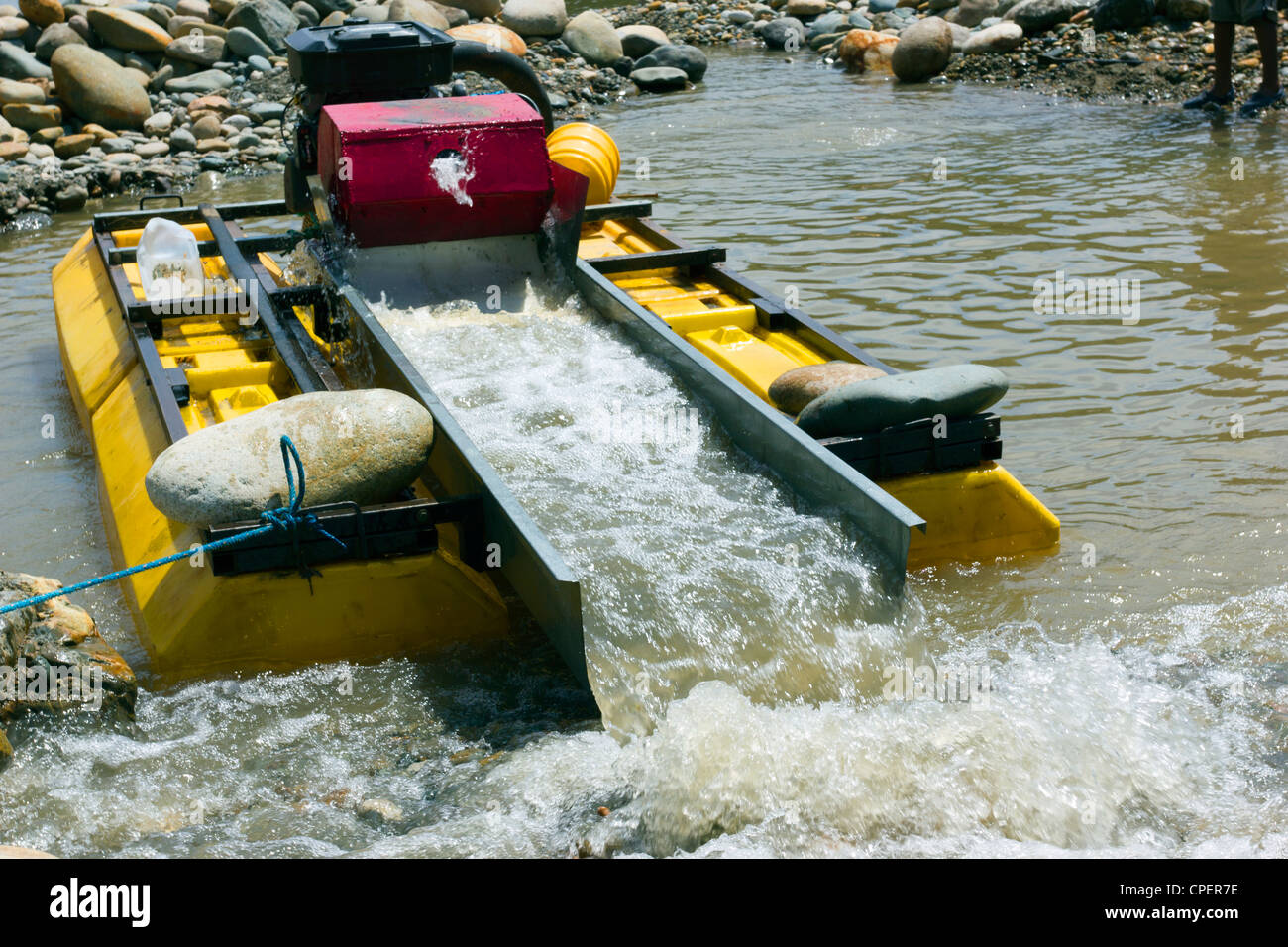 Suction dredge mining alluvial gold on an Amazonian riverbank in Ecuador Stock Photo