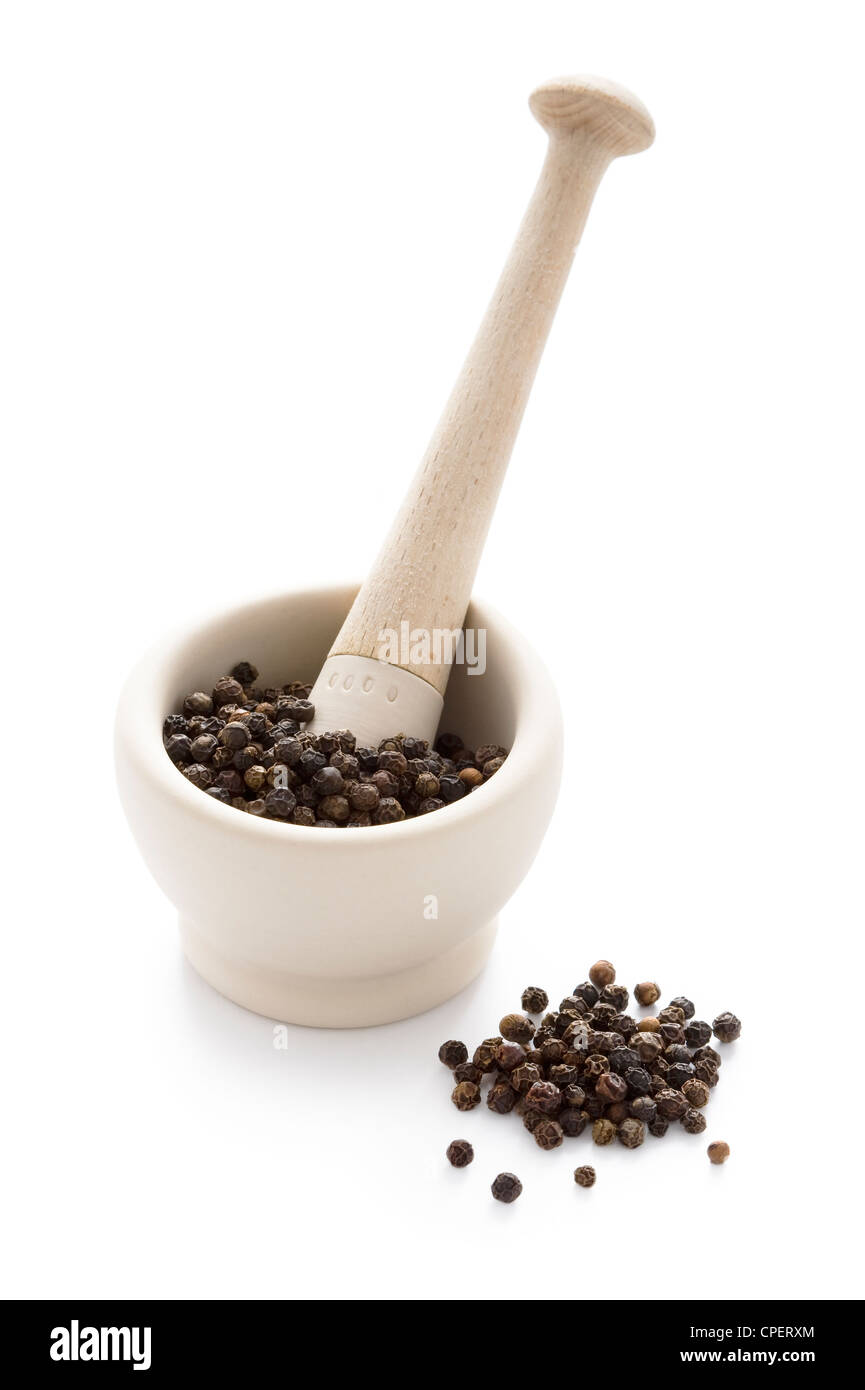 black peppercorns in a white pestle and mortar isolated Stock Photo