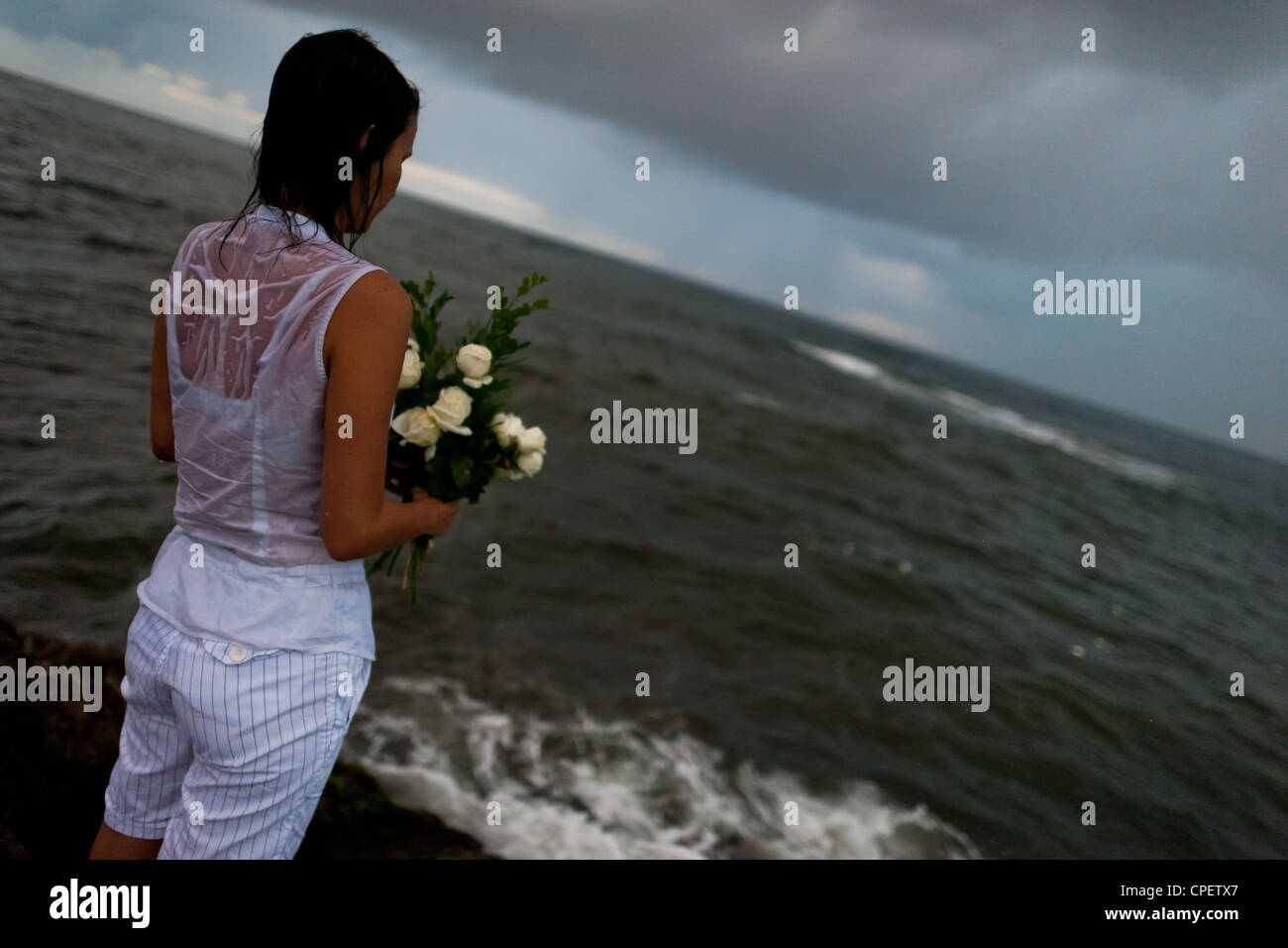 A Candomblé faithful throws flowers in the sea during the celebration