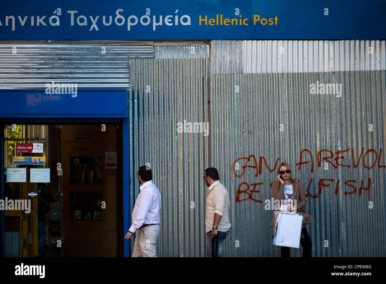 Graffiti (can a revolution be selfish) by the boarded up central post office of Athens Stock Photo