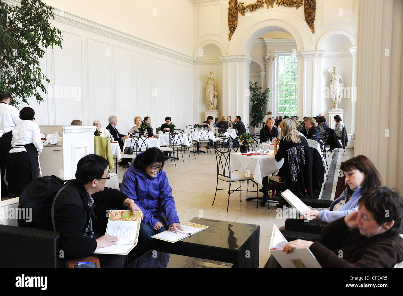The Orangery in Kensington Gardens in London with customers sitting at tables inside the restaurant. Stock Photo