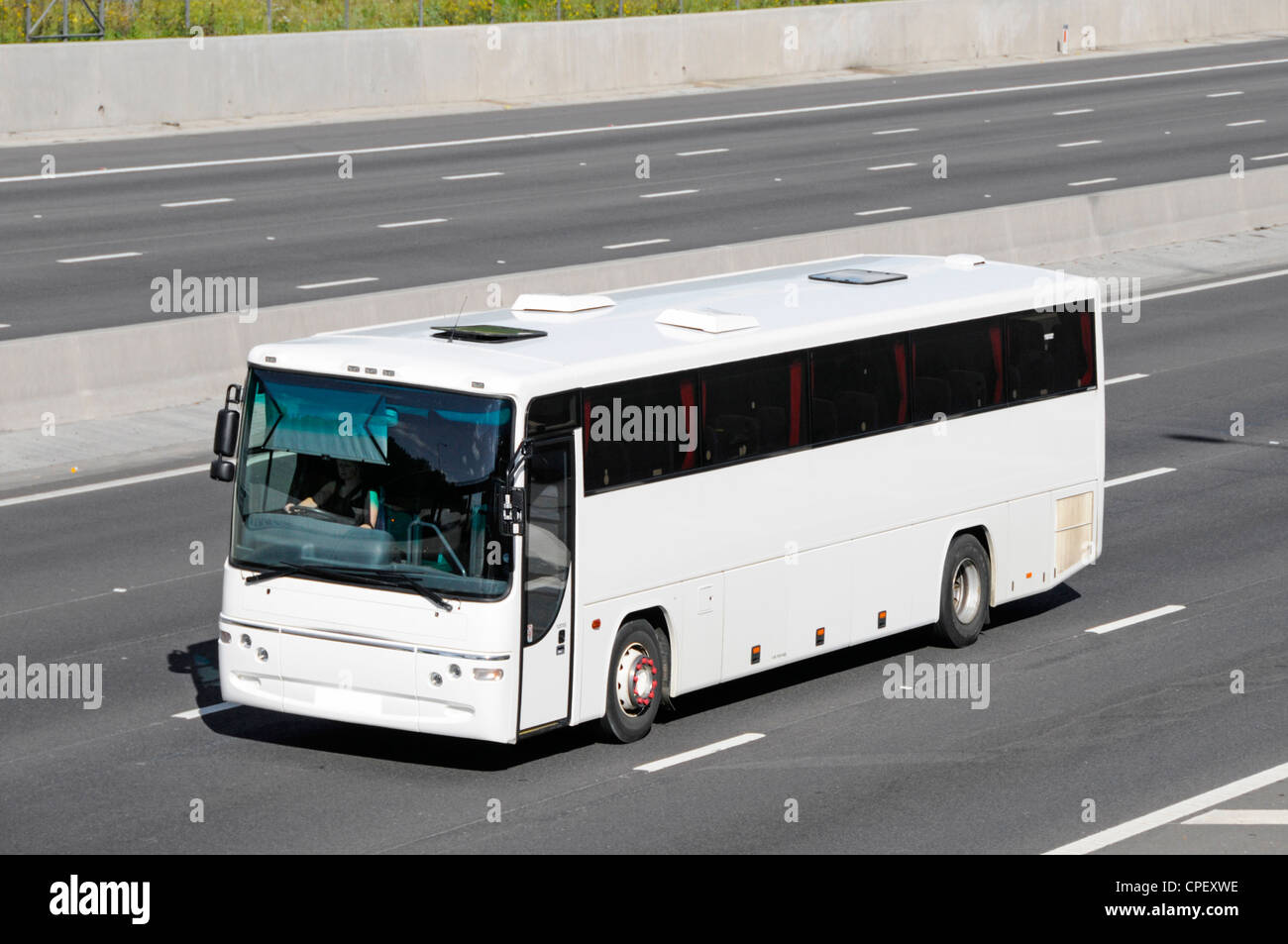 White unmarked clean Scania transport bus coach obscured number plate driving along M25 Motorway Essex England UK Stock Photo