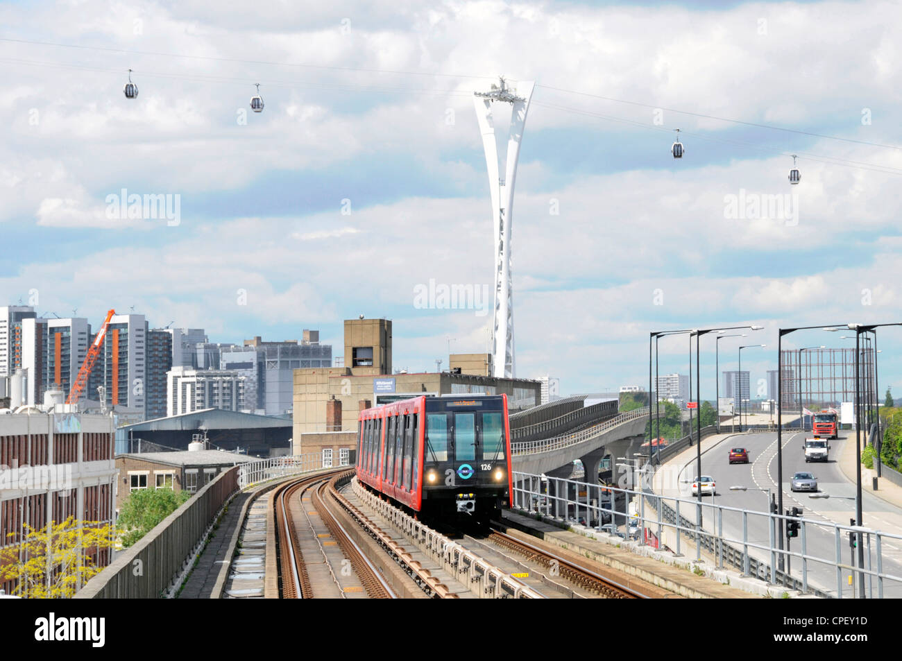 Docklands light railway train with Emirates Air Line cable car gondolas beyond Stock Photo