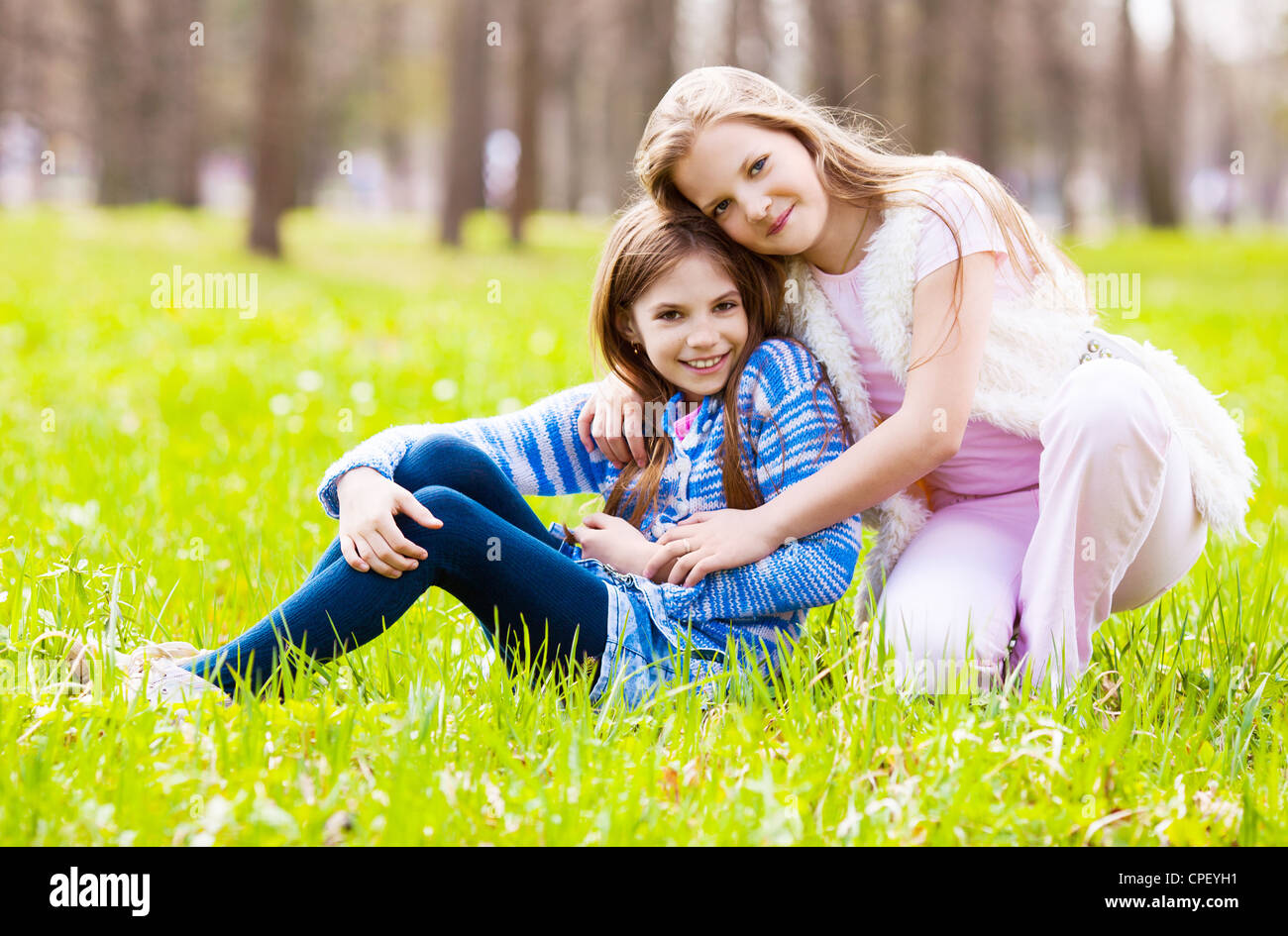 two girls embracing and laughing in the summer park Stock Photo - Alamy